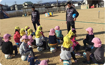 サッカー講師が子供たちに話している様子